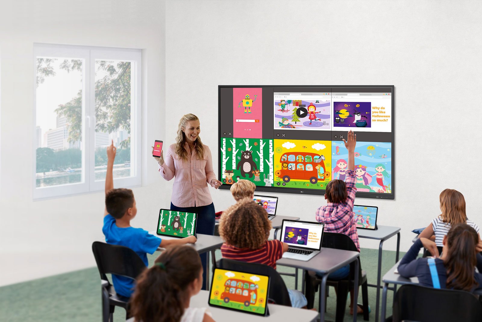 Teaching holding up a cell phone in front of class and flat panel