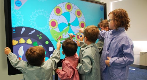 Kids playing with interactive board.