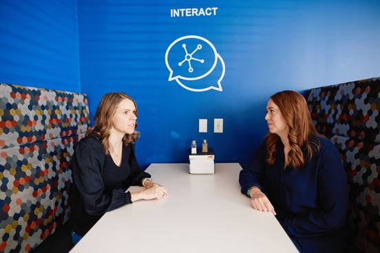 2 people talking at a table.