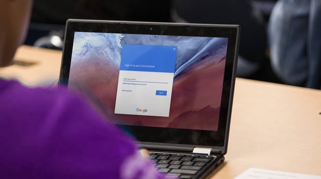 A student looking at Chromebook with security screen.