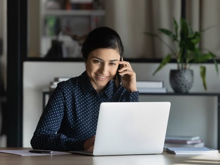 Woman on the phone while using laptop