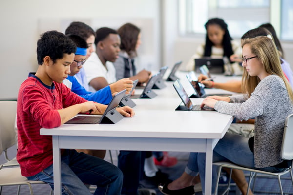 Kids on tablets at a table