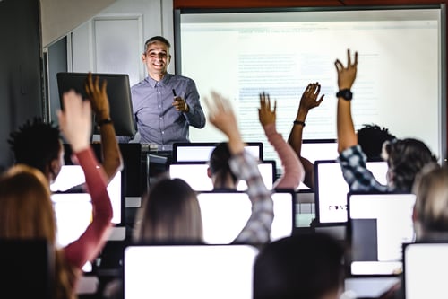 kids raising their hands in class