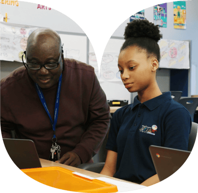 Teacher and student in a classroom on a chromebook.