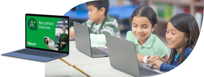Students engaged with laptops in a classroom, smiling and focused on their screens. A laptop displays "A+ Recrafted Devices."