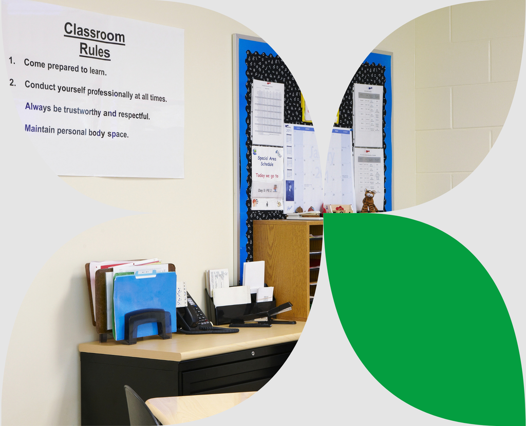 Teachers desk with organized paperwork in a typical classroom setting