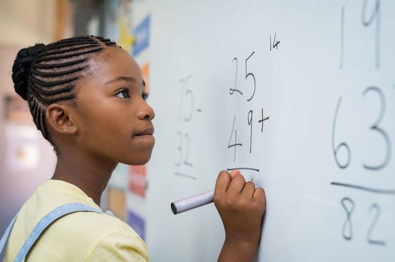 Girl doing math on a whiteboard