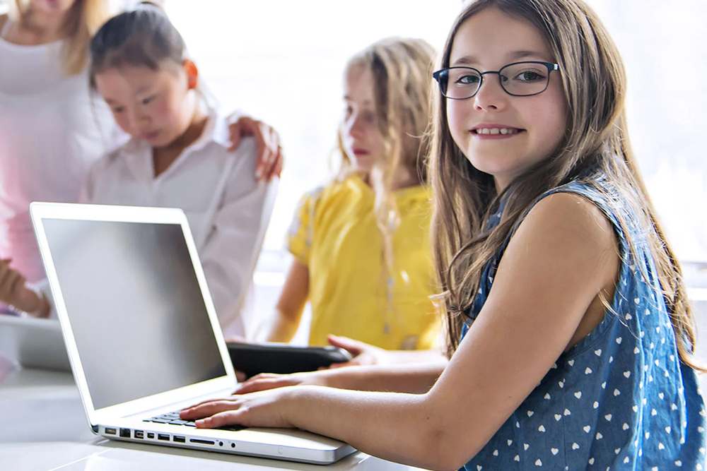 Girl sitting at a desk with a laptop