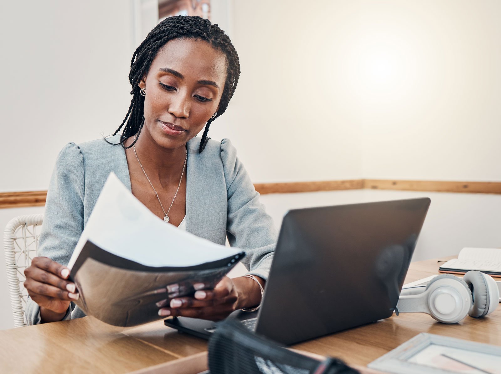 Woman looking at assessment paperwork in front of laptop