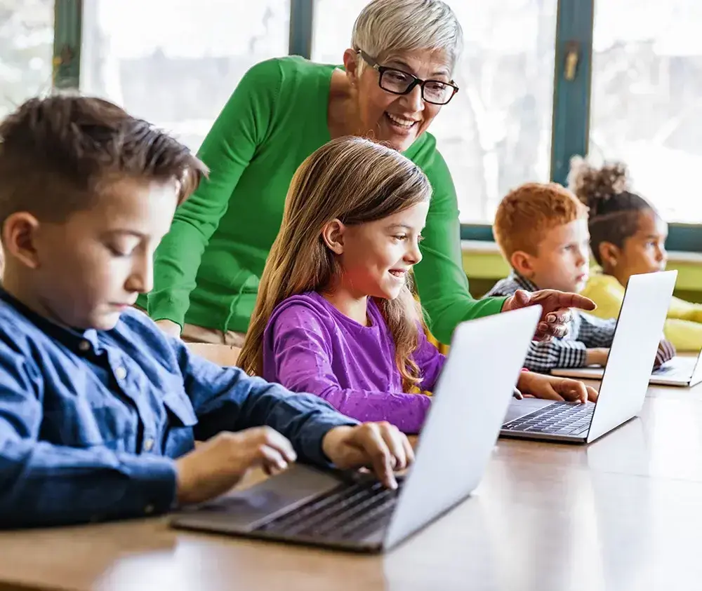 Classroom_Teacher&Students_Laptops_iStock-1327072542_1000x843 (1)