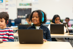 Girl on a computer in a classroom.