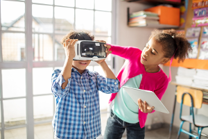 2 kids playing with a virtual reality headset.